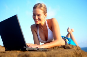 beautiful young woman on the beach with laptop